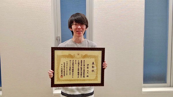表彰状を持つ伊藤の写真