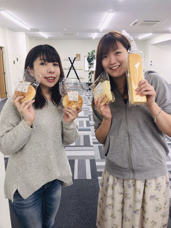 パンを持つ鹿角オフィススタッフの女子たちの写真